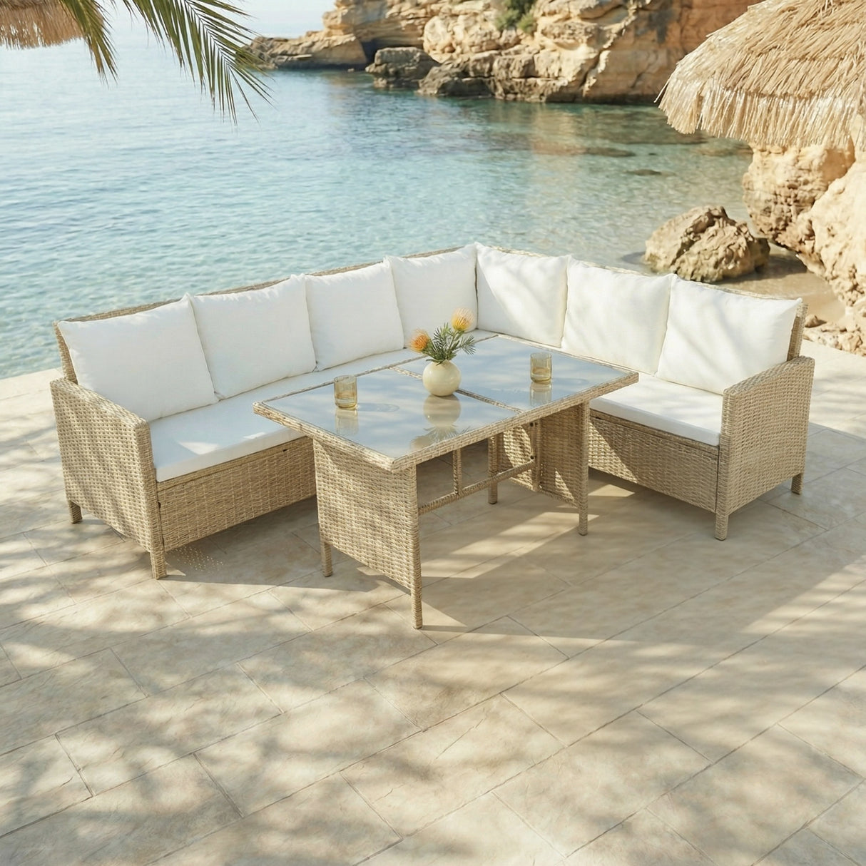 Outdoor patio furniture set with white cushions by a body of water.