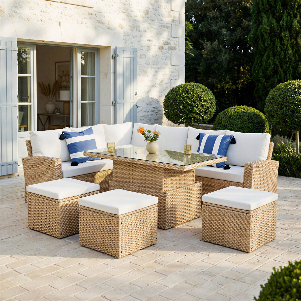 Outdoor patio set with wicker furniture and cushions on a stone patio.