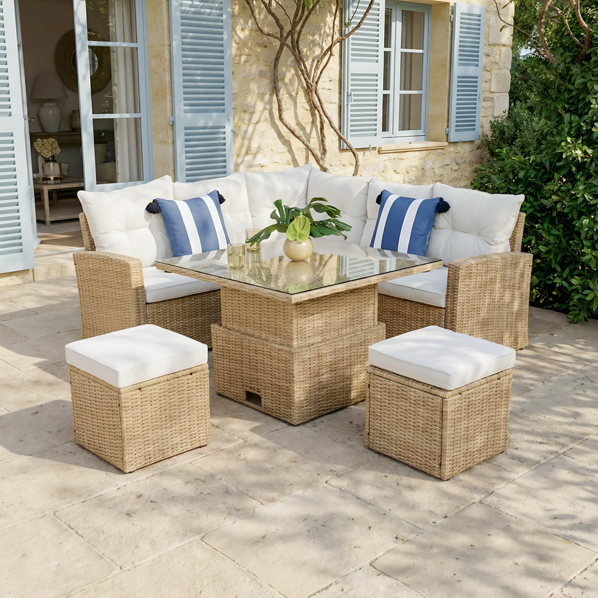 Outdoor patio furniture set with cushions on a stone patio.