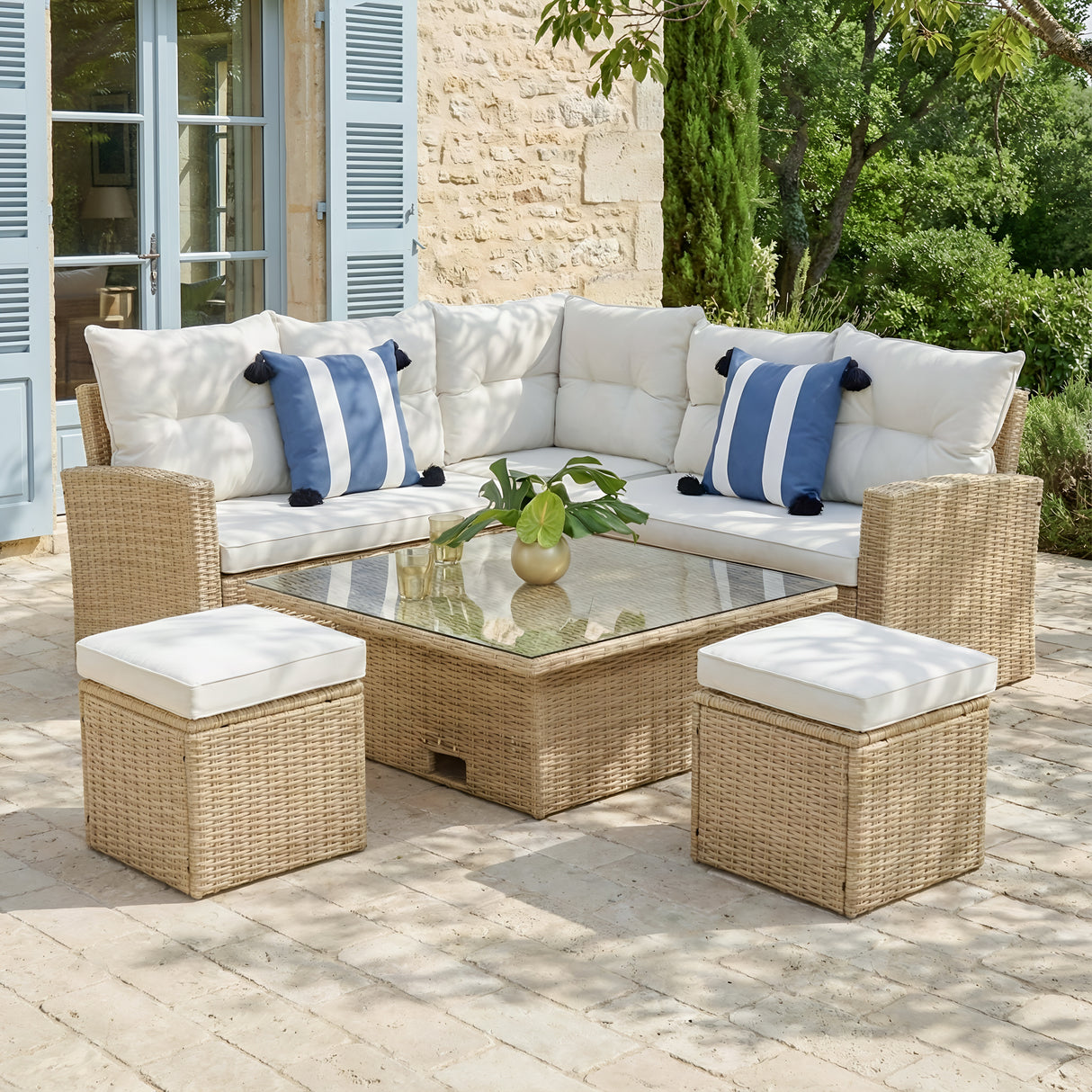 Outdoor patio furniture set with cushions on a stone patio.