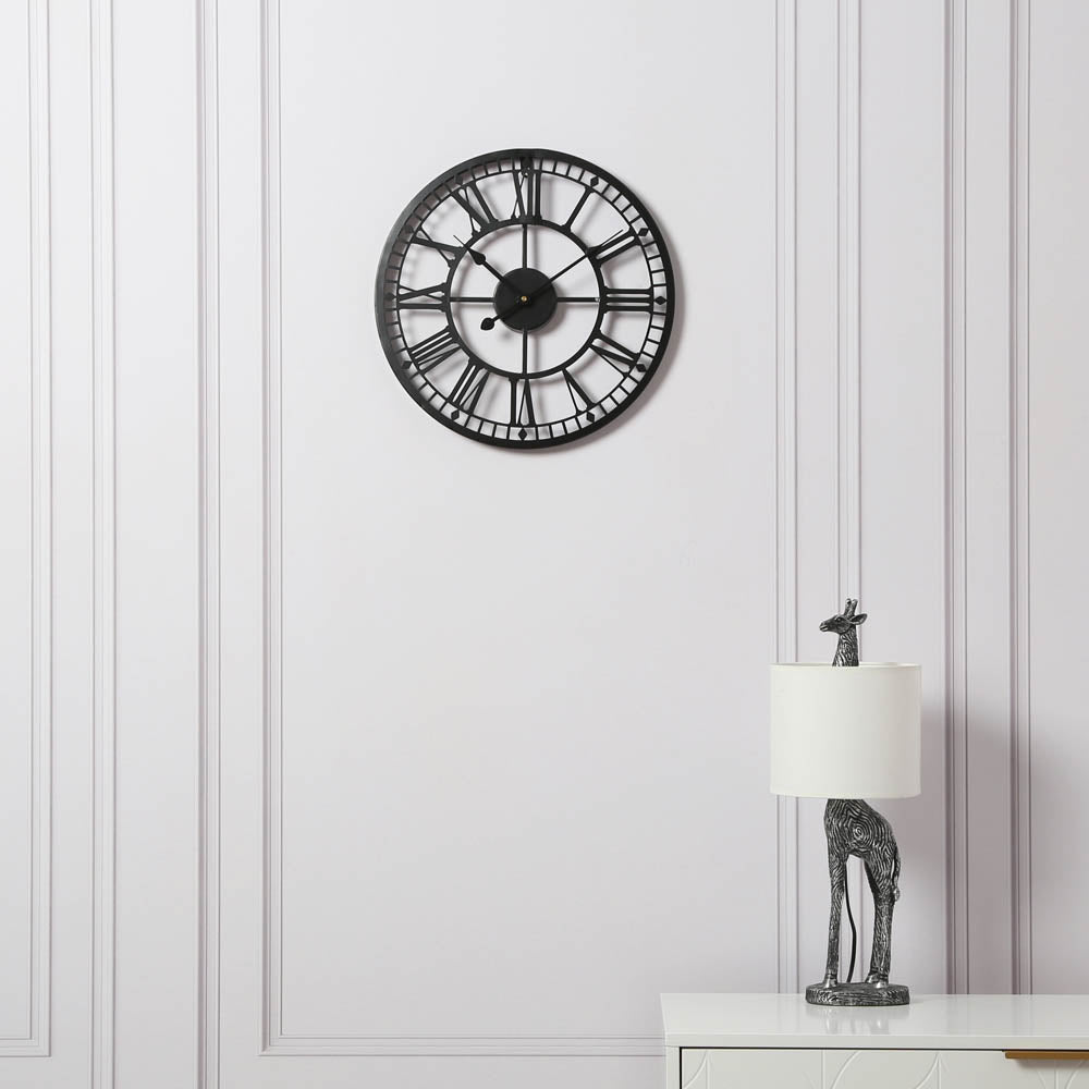 Black EOS skeleton wall clock displayed in a modern white interior
