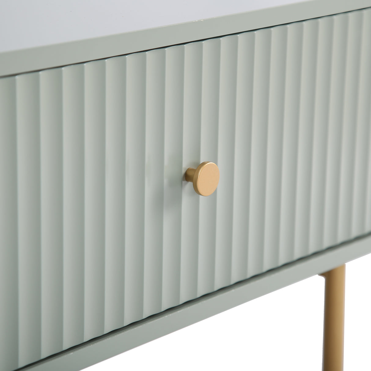 Close up of the sage green Devon Rectangular Coffee Table fluted drawer front, gold handle and gold leg.