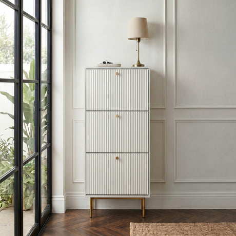 White Devon Shoe Cabinet with three fluted compartments, gold handles and slim gold legs, styled in a modern hallway.
