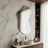 Lesina Frameless Pond Mirror styled above a bathroom vanity against a marble wall.