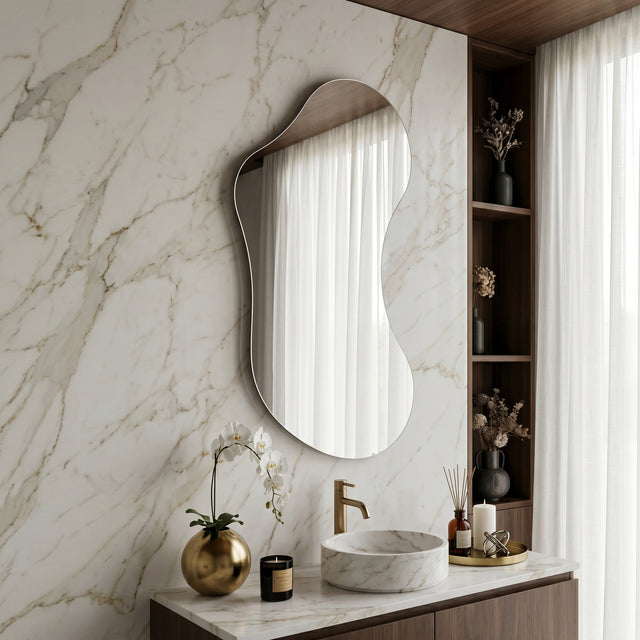 Lesina Frameless Pond Mirror styled above a bathroom vanity against a marble wall.