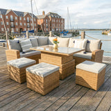 Outdoor patio set with cushions on a wooden deck by a waterfront.