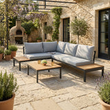 Outdoor patio with a sectional sofa, coffee table, and stone pavement.
