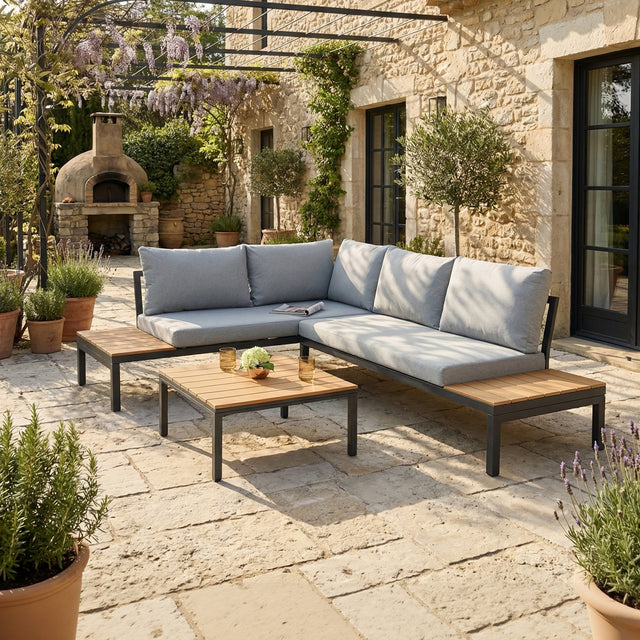 Outdoor patio with a sectional sofa, coffee table, and stone pavement.