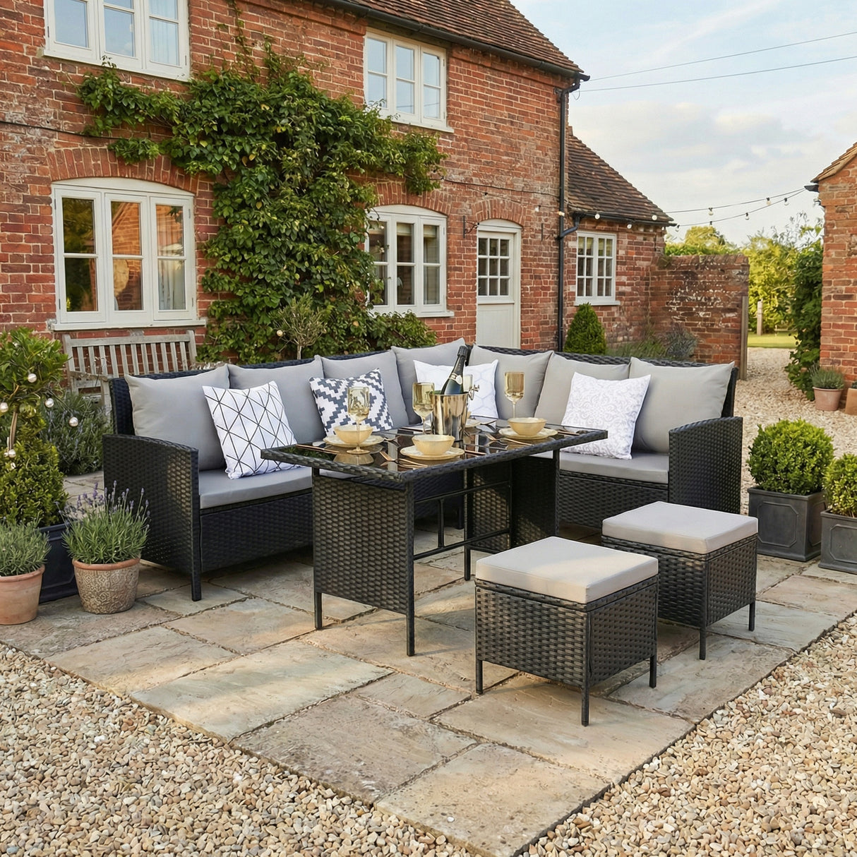 Outdoor patio set with cushions in front of a brick house
